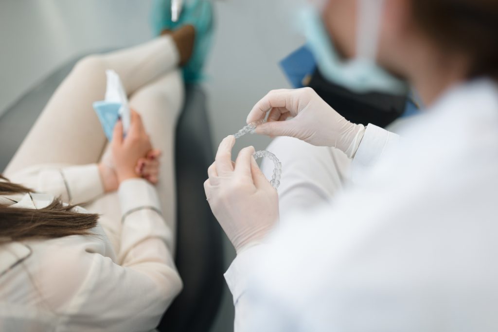 Professional dentist showing and explaining an invisalign to a client